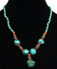 Collier ethnique artisanal imitation quatre pierres difformes turquoises agrémentées de perles en métal, vertes et en bois Collier ethnique artisanal imitation quatre pierres difformes turquoises agrémentées de perles en métal, vertes et en bois