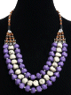 Collier ethnique artisanal trois rangs imitation pierres blanches et mauves agrémentées de perles et de pièces argentées Collier ethnique artisanal trois rangs imitation pierres blanches et mauves agrémentées de perles et de pièces argentées