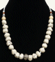 Collier ethnique artisanal imitation boules blanches difformes separees de perles blanche avec une boule en metal au milieu